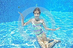 Child swims in pool underwater, happy active girl has fun under water, kid sport