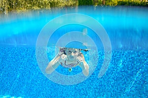 Child swims in pool underwater, happy active girl has fun under water, kid sport