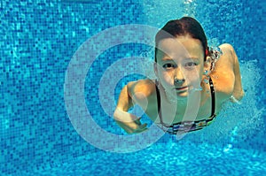 Child swims in pool underwater, happy active girl jumps, dives and has fun, kid sport