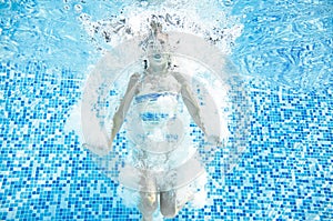 Child swims in swimming pool underwater, happy active girl jumps, dives and has fun under water, kids fitness and sport