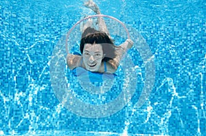 Child swims in swimming pool underwater, happy active teenager girl dives and has fun under water, kid fitness and sport