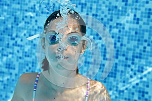 Child swims in swimming pool underwater, happy active teenager girl dives and has fun under water, kid fitness and sport