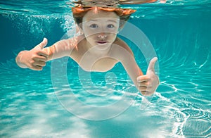 Child swims underwater in swimming pool, happy active boy dives and has fun under water, kids watersport. Children play