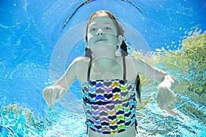 Child swims underwater in swimming pool, happy active teenager girl dives and has fun under water, kid fitness and sport