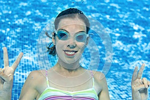 Child swims underwater in swimming pool, happy active teenager girl dives and has fun under water, kid fitness and sport