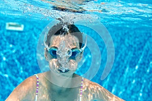 Child swims underwater in swimming pool, happy active teenager girl dives and has fun under water, kid fitness and sport