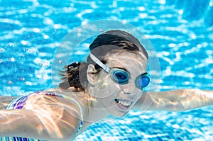 Child swims underwater in swimming pool, happy active teenager girl dives and has fun under water, kid fitness and sport