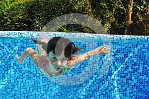 Child swims underwater in swimming pool, happy active teenager girl dives and has fun under water, kid fitness and sport