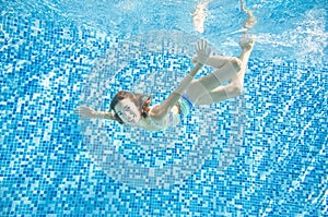 Child swims underwater in swimming pool, little active girl dives and has fun under water, kid fitness and sport