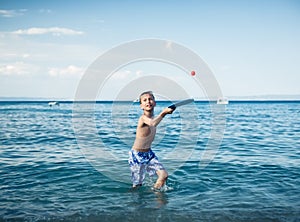 Child in swimware playing in sea