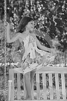 Child swing on backyard. Kid playing outdoor. Happy cute little girl swinging and having fun healthy summer vacation