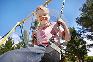 Child, swing and fun on playground in portrait, smile and outdoor adventure in childhood for recreation at park. Happy