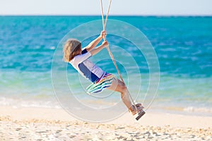 Child on swing. Kid swinging on beach