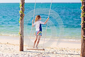 Child on swing. Kid swinging on beach
