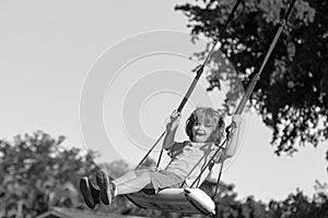 Child swing outdoor. Kid playing on backyard. Happy cute little boy swinging and having fun healthy summer vacation