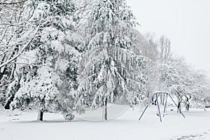 Child swing set dusted with snow in a snow covered parkland