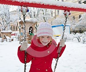 Child on swing in winter park