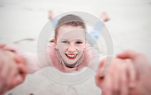 Child swinging from hands at beach, pov and happy, smile and laugh. Fun time, motion or girl in garden spinning from