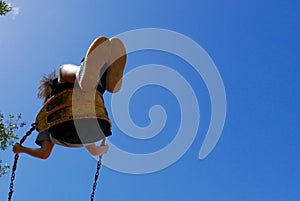 Child swinging high on a playground swing