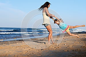 Child swinging parent beach