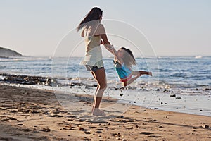 Child swinging parent beach