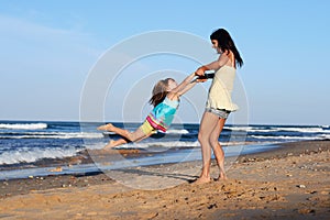 Child swinging parent beach