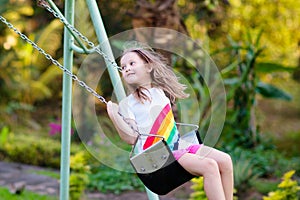 Child swinging on playground. Kids swing