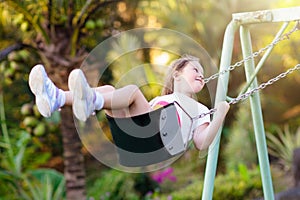 Child swinging on playground. Kids swing photo