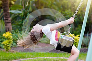 Child swinging on playground. Kids swing photo