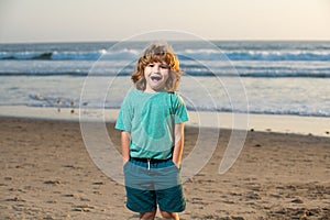 Child in t-shirt walking on the summer beach. Amazed surprised kids emotions.