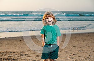 Child in t-shirt walking on the summer beach. Amazed surprised kids emotions.