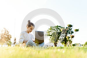 Child with tablet pc outdoors. Little girl on grass with computer