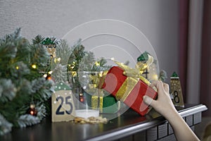 Child takes gifts from Santa. Christmas concept with milk and cookies. Advent calendar, caronavirus medical mask and Christmas