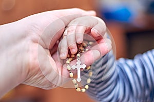 A child takes a rosary from his dad`s hand