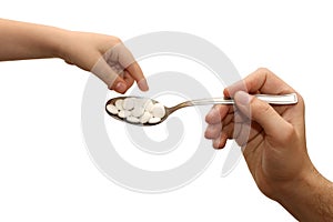 Child takes the tablets with a spoon photo