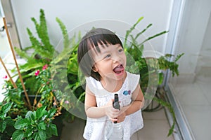 Child taking care of plants. Cute little girl watering first spring flowers