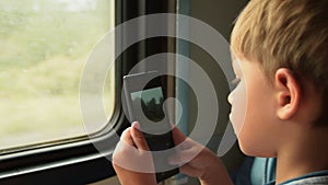 Child taking cellphone pictures in train