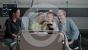 Child taking selfie with patient and family in visit using smartphone