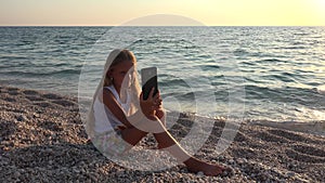 Child Taking Selfie Via Smartphone on Beach, Kid at Sunset, Girl Playing Tablet