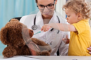 Child taking temperature of teddy bear