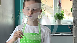 Child tasting cream from mixer stirrer.