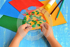 Child tearing colored paper into pieces. Home activity to improve fine motor skill development. Baby play. How to work with paper photo