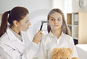 Otolaryngologist doing ENT examination of child during medical checkup at her office