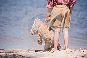 Child with teddy bear at seashore