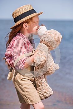 Child with teddy bear at seashore