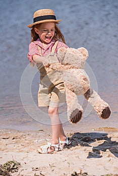 Child with teddy bear at seashore