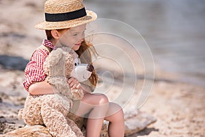 Child with teddy bear at seashore