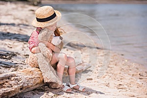 Child with teddy bear at seashore