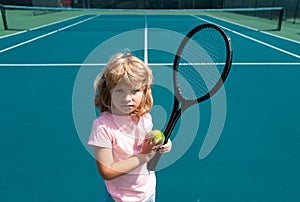 Child with tennis racket and ball on tennis court outdoor. Sport exercise for kids. Summer activities for children