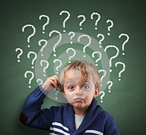 Child thinking with question mark on blackboard